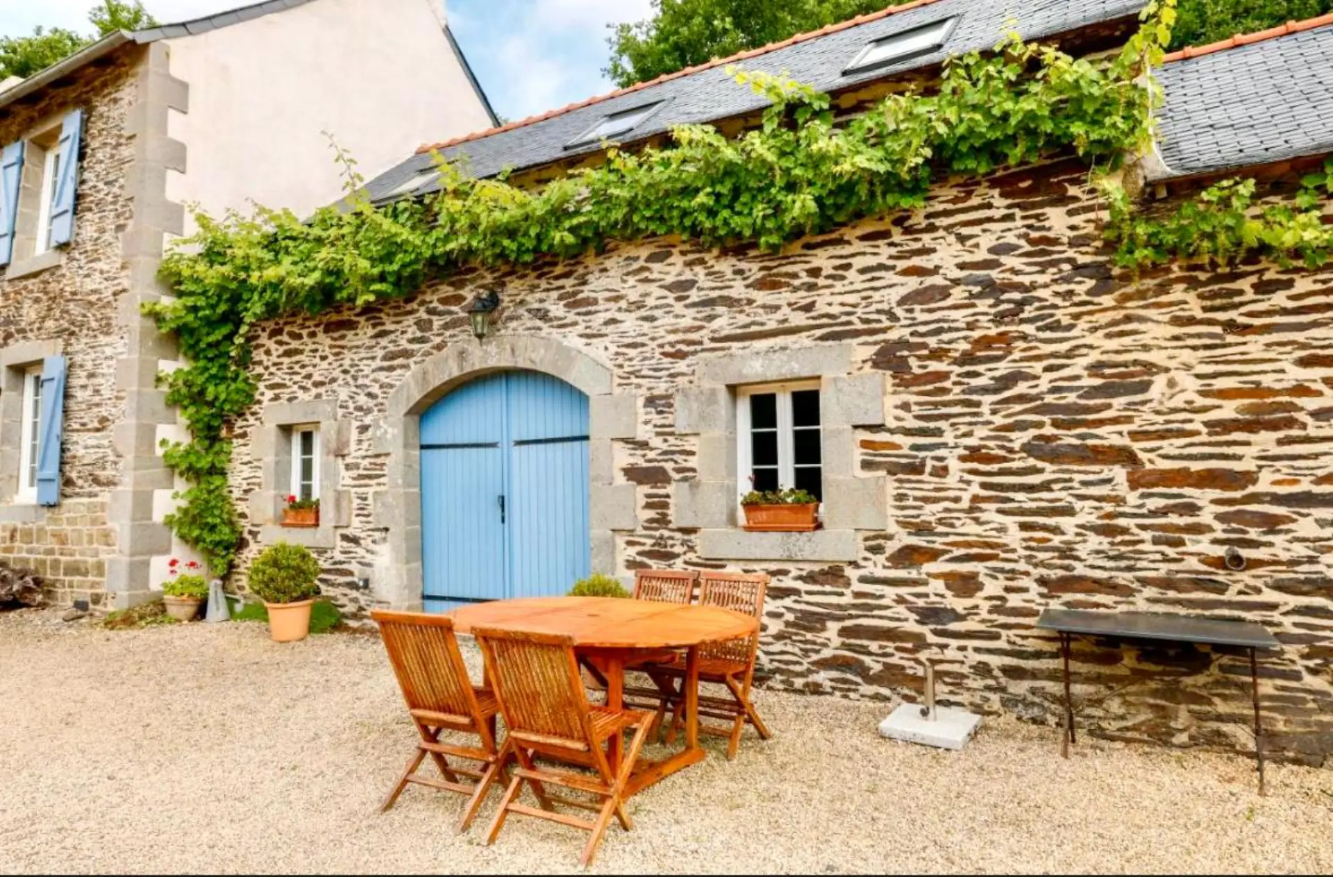Façade du gîte de charme à Lopérec, Finistère, avec vigne grimpante et terrasse ensoleillée