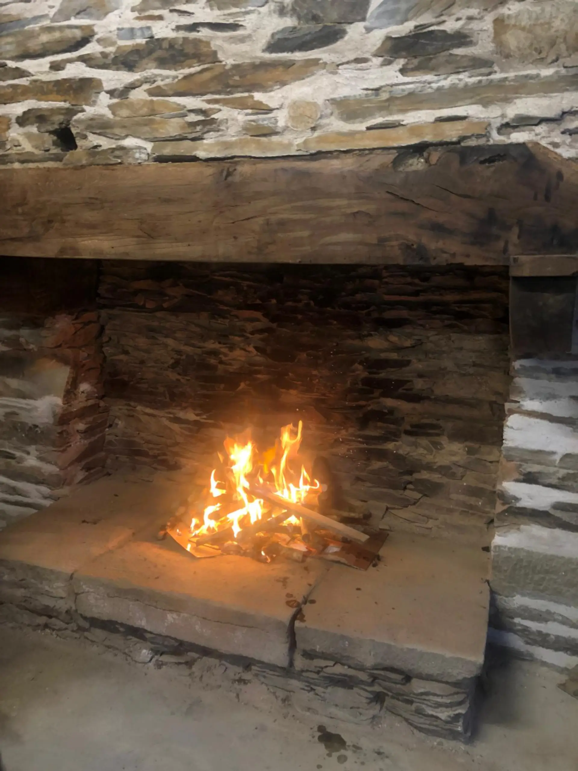 Feu de cheminée dans le salon en pierre du gîte du Dourdu